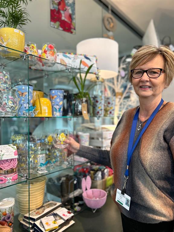 Photo of a woman setting up merchandise on a shelf 