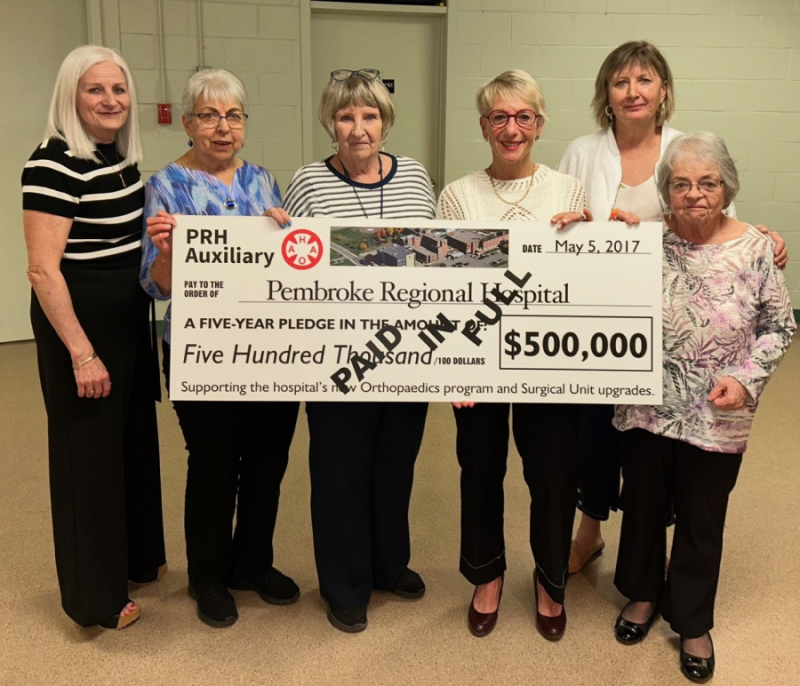 group of ladies holding a large cheque with donation amount 